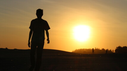 silhouette of a man standing on the beach at sunset