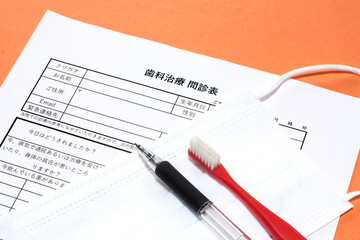 歯科問診票とマスクと歯ブラシ