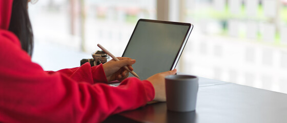 Female in red sweater hands working with mock up digital tablet