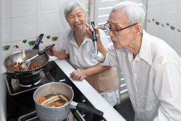 Asian senior people cooking,tasting vegetables soup,old elderly enjoying preparing meal Thai food in kitchen at home,healthy food,good cook,economical,hygienic,concoction,delicious and clean concept.