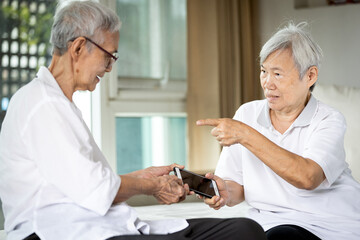 Senior women fighting or conflict for smartphone,sibling in old age or two elderly pulling apart mobile phone,quarreling,arguing,addicted to online movies,social networking,internet addiction problems