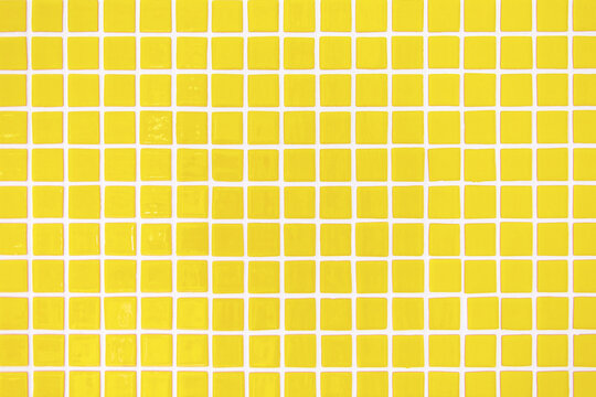 Square yellow ceramic tiles texture. Trendy interior background pattern. 2021 color trend.