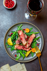 Grilled beef steak salad with arugula, potatoes, carrots, onions and pomegranate. Healthy eating. Diet.