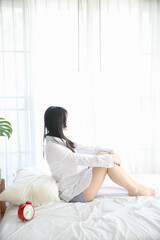 Obraz na płótnie Canvas Portrait beautiful asian girl sitting with clock at white bedroom