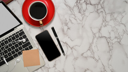 Marble desk with smartphone, laptop, aceesories, coffee cup and copy space