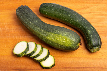 green sliced zucchini on a wooden cutting board