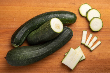 green sliced zucchini on a wooden cutting board