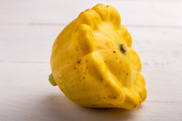 yellow pattypan squash on a white wooden table