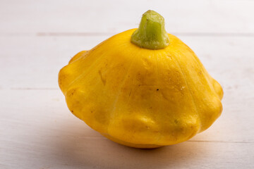 yellow pattypan squash on a white wooden table