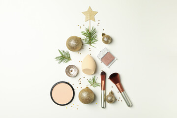 Christmas tree made of cosmetics and baubles on white background