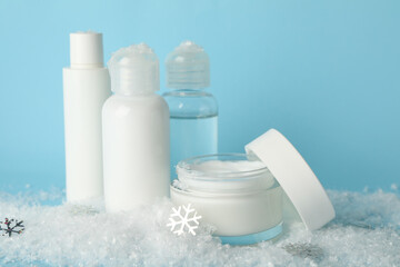 Concept of face care with cosmetics on background with decorative snow