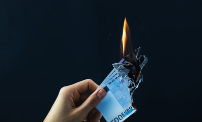 Euro banknotes burn on a black isolated background. World crisis concept.