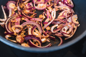 simple food ingredients, close-up of caramelised red Spanish onions in a pan with roaste minced garlic