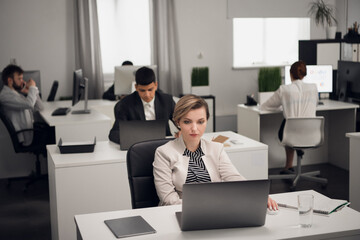 Customer service Manager at the workplace at the table with a laptop