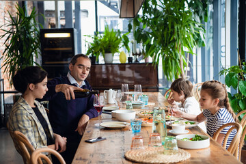 A family of four having a dinner in a cafe.