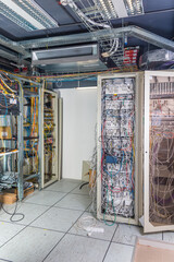 server room rack with tangled network cables creating messy unti