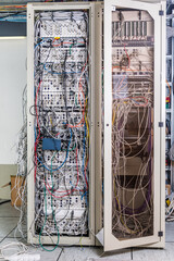 server room rack with tangled network cables creating messy unti