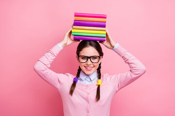 Photo of pretty student lady hold literature pile on head good mood like reading preparing examination college university wear shirt pullover specs isolated pink color background