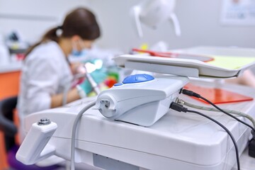 Dental office background, professional equipment, doctor treating teeth to patient out of focus