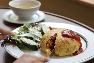 Japanese cuisine: omurice with rice, chicken and vegetables close-up on the table.
