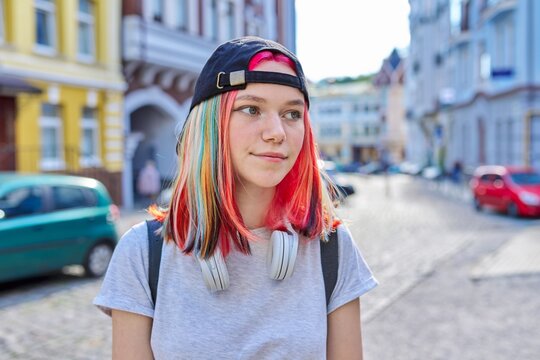 Portrait of fashionable hipster teenage girl with colored dyed hair in black cap