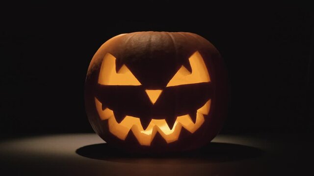 Pumpkin glows on Halloween night. Traditional Halloween symbol. Halloween pumpkin smile and scary eyes for party night. Horror Halloween concept.