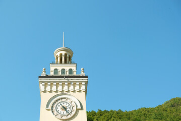 Fototapeta premium Clock tower in Rosa Khutor, Sochi, Russia. The top of the tower against a blue sky