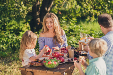 Portrait of nice attractive cheerful family brother sister siblings spending free time weekend on fresh air eating ripe fruits berries rest relax upbringing in green park