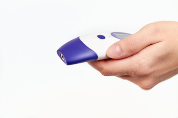 Woman's hand holds an electronic non-contact thermometer on white background