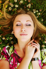 young beautiful girl lays on a grass