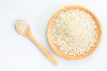 Heap of raw rice on wooden bowl and spoon