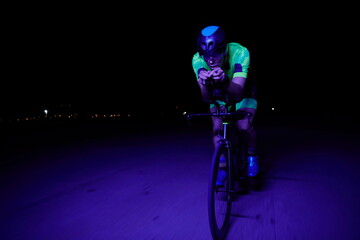 Fototapeta na wymiar triathlon athlete riding bike fast at night