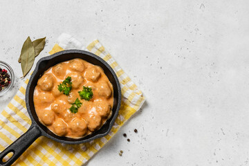 Cheesy meatballs casserole  in cast iron skillet. space for text.