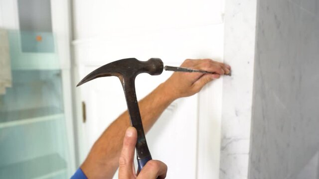 4K Craftsman gently using a hammer and chisel on marble bath