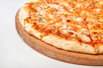 Pizza with cheese, bacon and tomatoes on wooden board. Close-up, selective focus