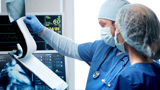 Professional medical doctors working in emergency medicine. Portrait of the surgeon and the nurse in protective masks performing surgical operation.