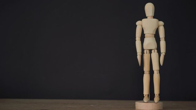 wooden statue on a black background.