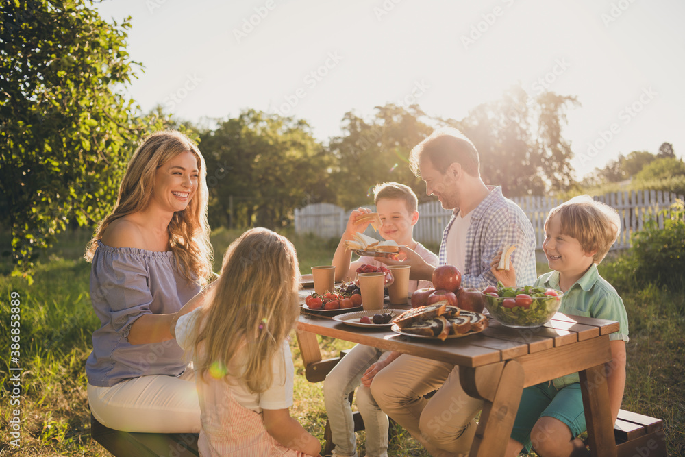 Wall mural photo of full big family five people three little kids sit bench table relax delicious dinner eat sa