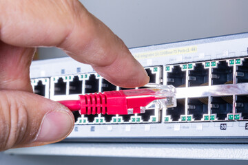 hand of network administrator plugging in network cable 