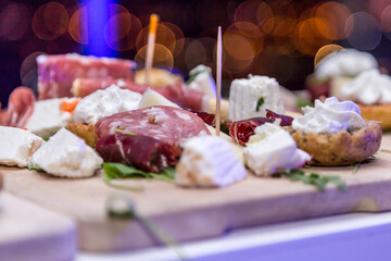Italian salami, prosciutto, bacon ricotta and Cheese on wooden chopping board