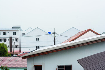 Red roof tiles, new houses during day, white fog
