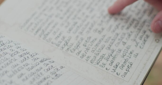  young woman reads her diary in autumn.detail of pointing index over a diary page. slow motion