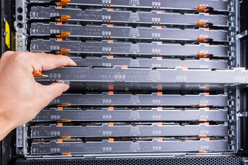 IT technician is opening hard disk array to exchange faulty hard