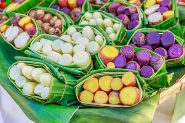 Sweet potatoes steamed and wrapped in fresh banana leaves at street food in Thailand