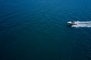 Obraz na płótnie Canvas Top view of a white boat sailing to the blue sea. Side view. Motor boat in the sea.Travel - image.