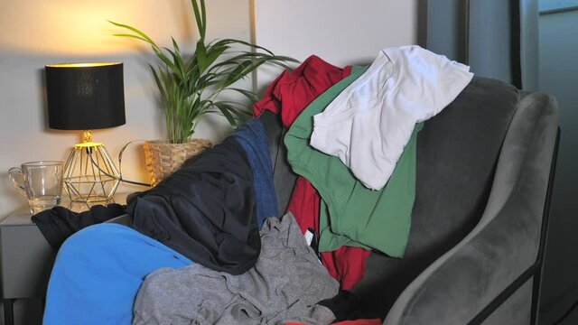 Cloths out of laundry thrown at armchair