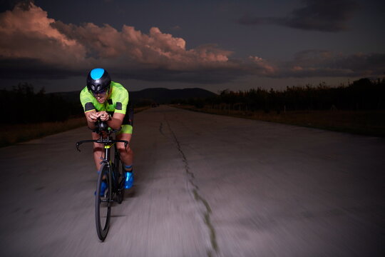 triathlon athlete riding bike fast at night © .shock