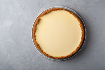 Homemade cooked cheesecake with delicate cream on gray background