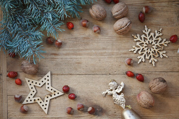 Christmas, New year card with fur tree, wooden decoration, dogrose, golden angle on wooden background