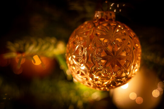 Glänzend goldene filigrane Weihnachtskugel mit Stern am Weihnachtsbaum